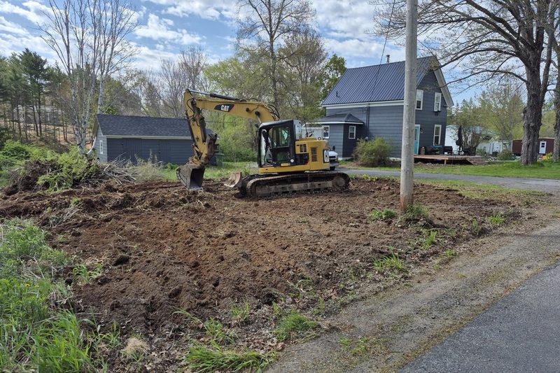 Excavator grading a freshly cleared residential lot