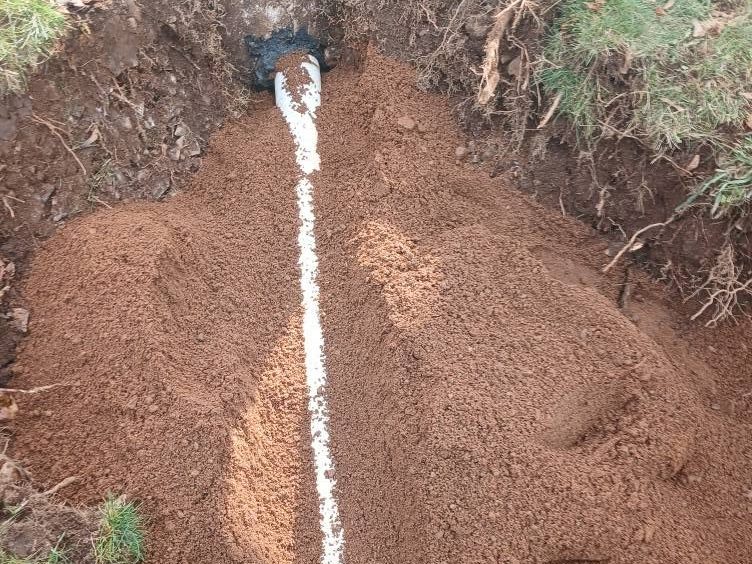 New outlet pipe bedded in a stone-lined trench